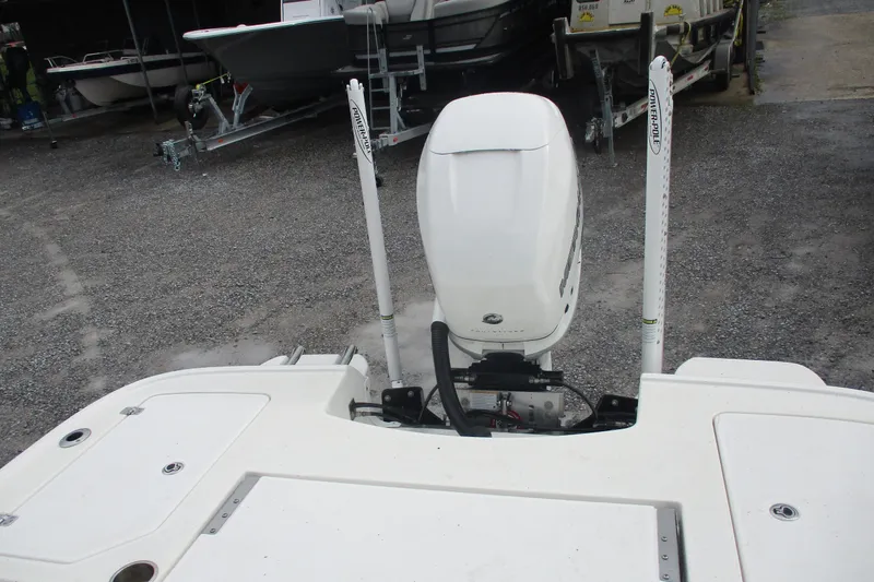 Slide: The Image of 2020 Caymas 28 HB boat with outboard motor and Power-Pole anchors in a gravel lot. - 10
