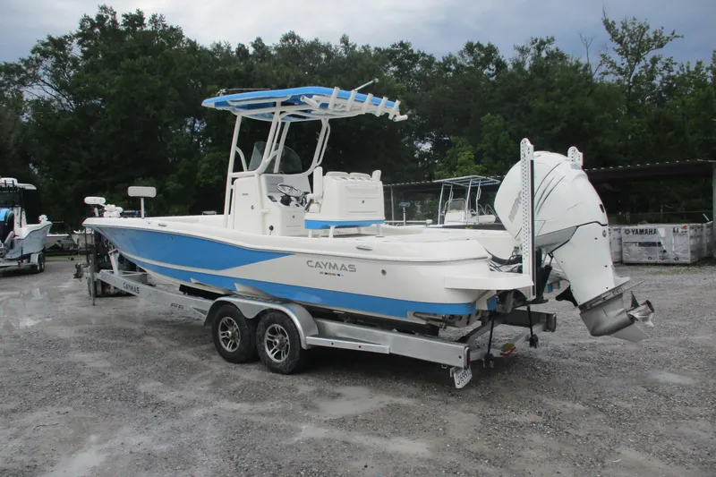 Slide: The Image of 2020 Caymas 28 HB boat on trailer, featuring blue and white design, parked outdoors. - 2