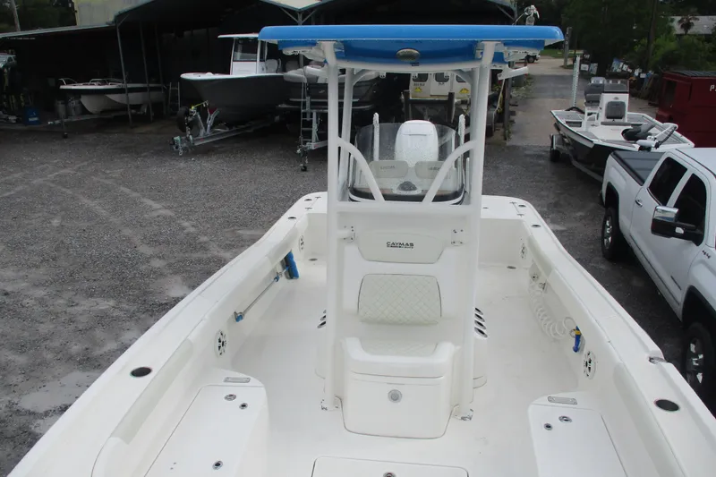 Slide: The Image of 2020 Caymas 28 HB boat with center console, parked in a gravel lot. - 7