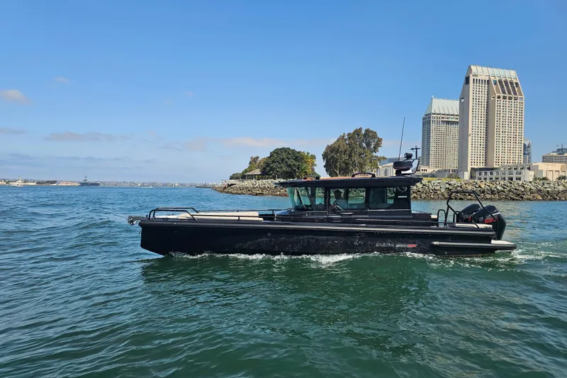 Slide: The Image of 2023 BRABUS Shadow 500 Black Ops boat cruising near city skyline. - 13