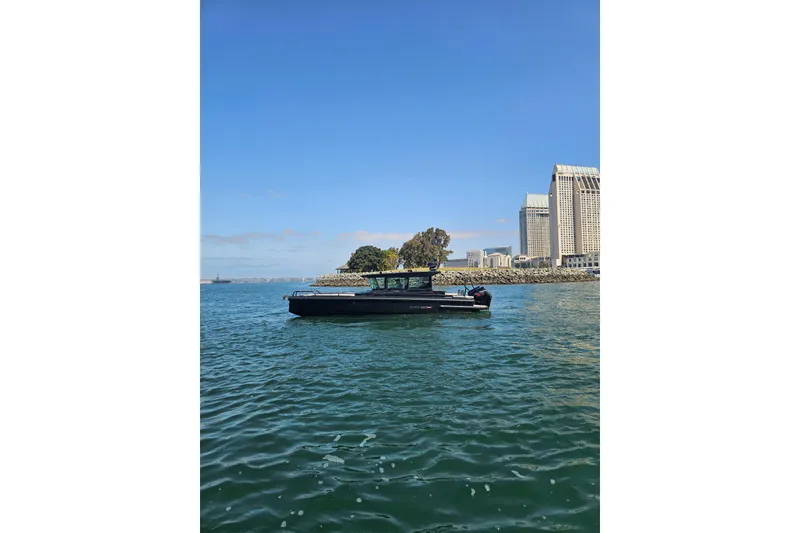 Slide: The Image of 2023 BRABUS Shadow 500 Black Ops boat cruising near city skyline. - 16
