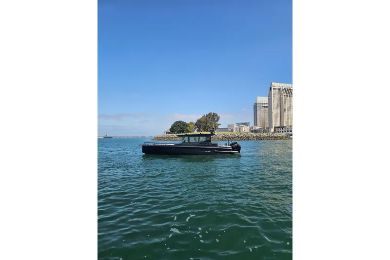 Slide: The Image of 2023 BRABUS Shadow 500 Black Ops boat cruising near urban waterfront skyline. - 17