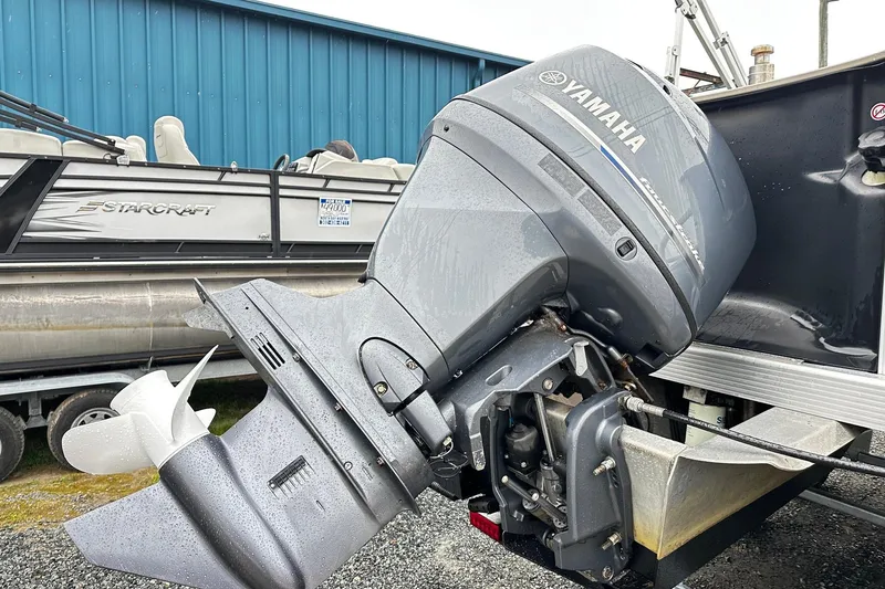 Slide: The Image of 2014 Bennington 2275SL Pontoon with Yamaha outboard motor, parked near a blue building. - 11