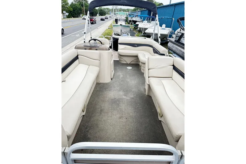 Slide: The Image of 2014 Bennington 2275SL Pontoon boat interior with beige seating and steering console. - 3