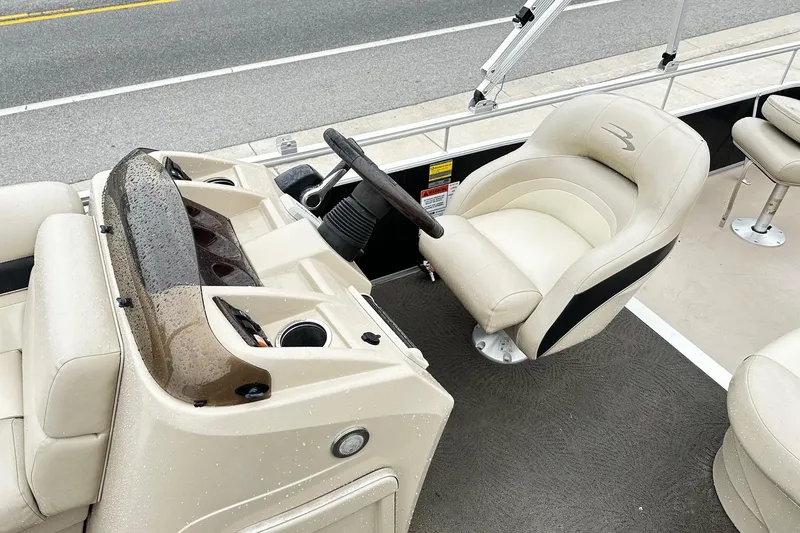 Slide: The Image of 2014 Bennington 2275SL Pontoon boat interior with steering console and plush seating. - 5