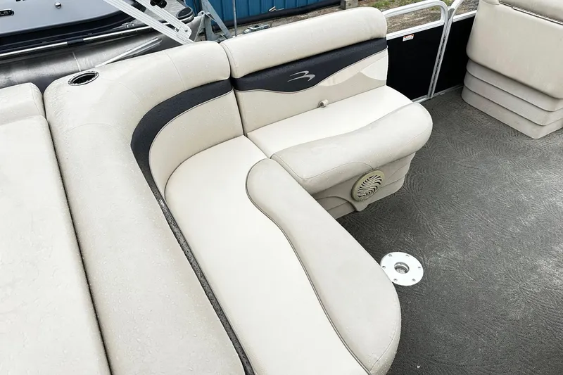 Slide: The Image of 2014 Bennington 2275SL Pontoon boat interior with beige seating and cup holder. - 8
