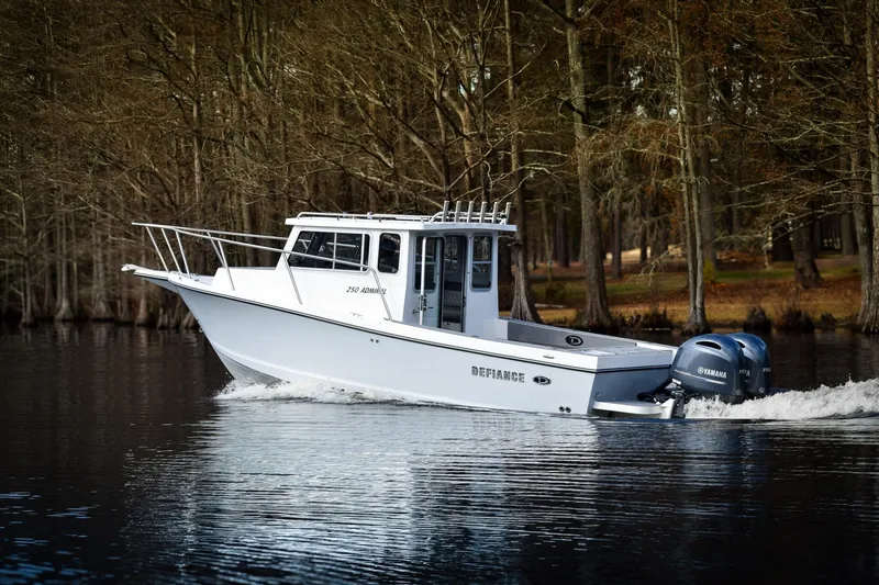 Slide: The Image of 2027 Defiance Admiral 250 EX boat cruising on a serene lake with forest backdrop. - 3