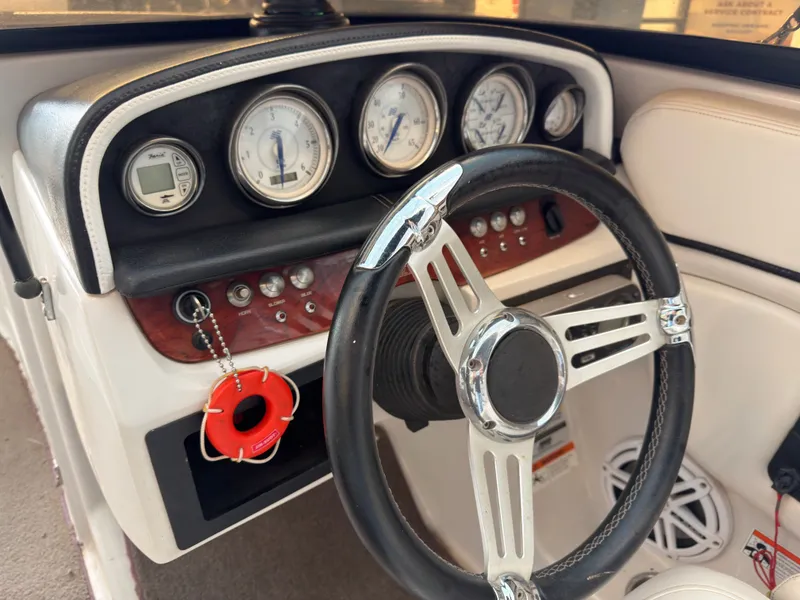 Slide: The Image of Dashboard of a 2008 Four Winns H210 boat with steering wheel and gauges. - 8
