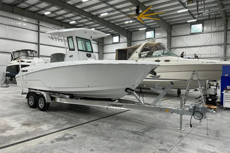 The Image of 2026 Wellcraft 243 Fisherman boat on trailer in indoor showroom. - 0