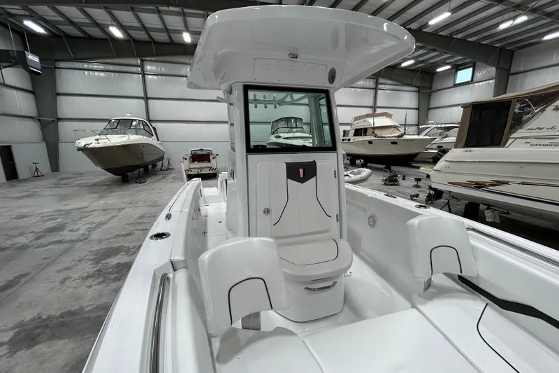 Slide: The Image of 2026 Wellcraft 243 Fisherman boat in a spacious indoor showroom. - 13