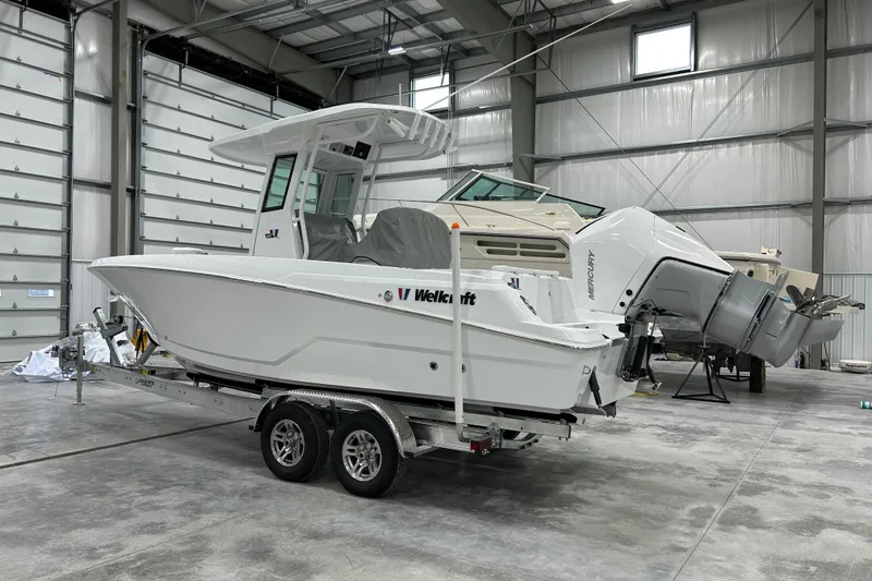 Slide: The Image of 2026 Wellcraft 243 Fisherman boat in a spacious indoor storage facility. - 2