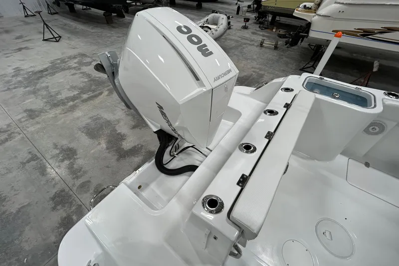 Slide: The Image of 2026 Wellcraft 243 Fisherman boat with Mercury outboard engine in a showroom. - 4