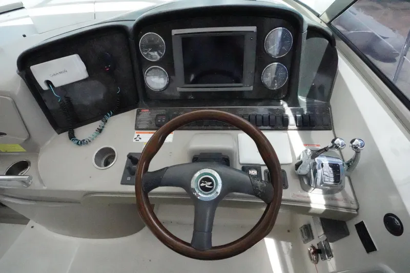 Slide: The Image of 2008 Sea Ray 380 Sundancer helm with steering wheel, gauges, and Garmin navigation system. - 11