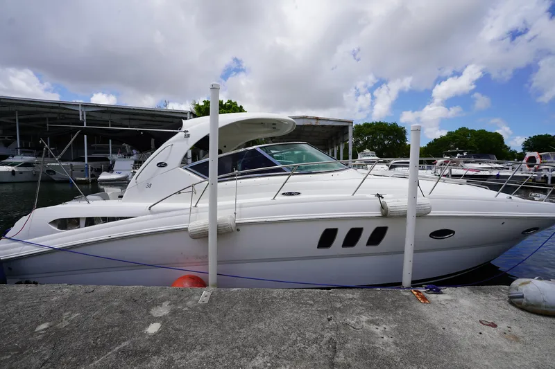 The Image of 2008 Sea Ray 380 Sundancer yacht docked at marina under cloudy sky. - 2
