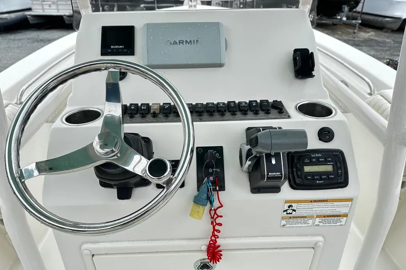 Slide: The Image of 2017 Sea Chaser 22 HFC boat dashboard with Garmin and Suzuki controls. - 4