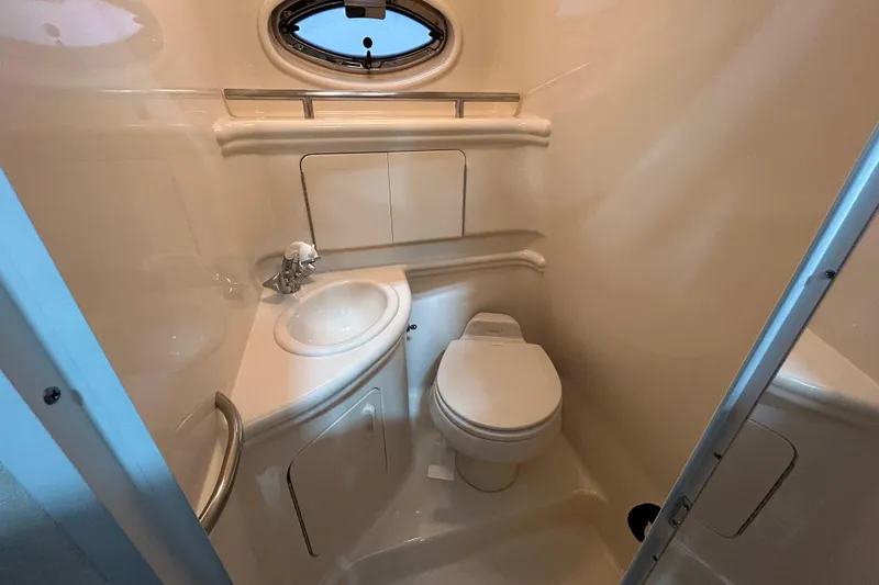 Slide: The Image of 2004 Sea Ray Sundancer 280 bathroom with sink, toilet, and porthole window. - 17