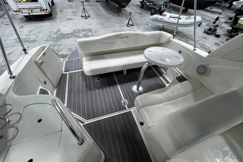 Slide: The Image of 2004 Sea Ray Sundancer 280 interior with seating and table in a boat storage area. - 6