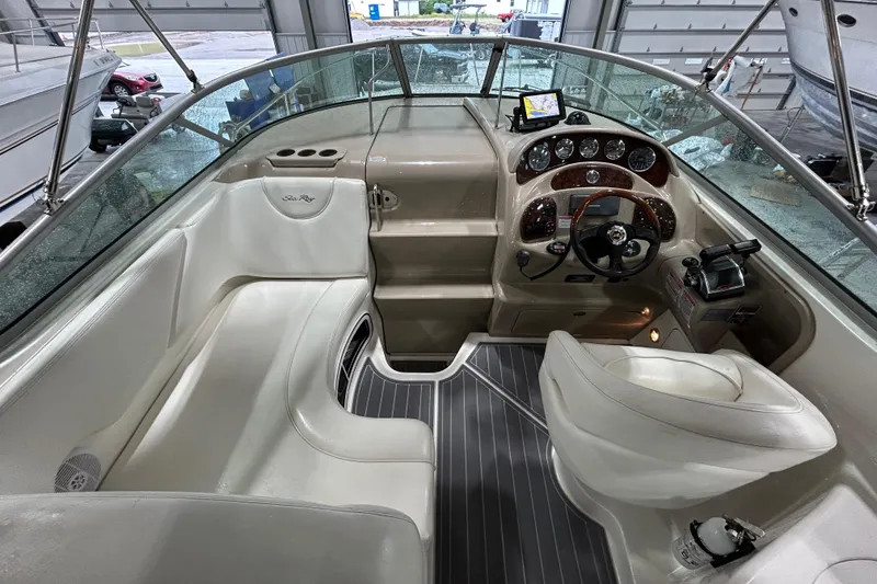 Slide: The Image of 2004 Sea Ray Sundancer 280 cockpit with steering wheel, gauges, and seating in a marina setting. - 7