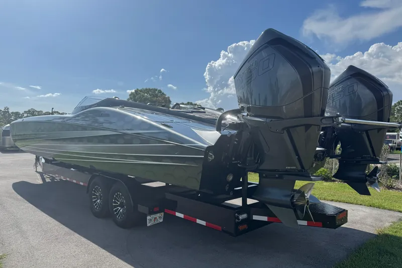 Slide: The Image of 2023 MTI 390X powerboat on trailer, featuring dual outboard engines under a clear blue sky. - 12