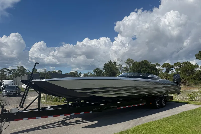 Slide: The Image of 2023 MTI 390X boat on trailer under blue sky with clouds. - 13