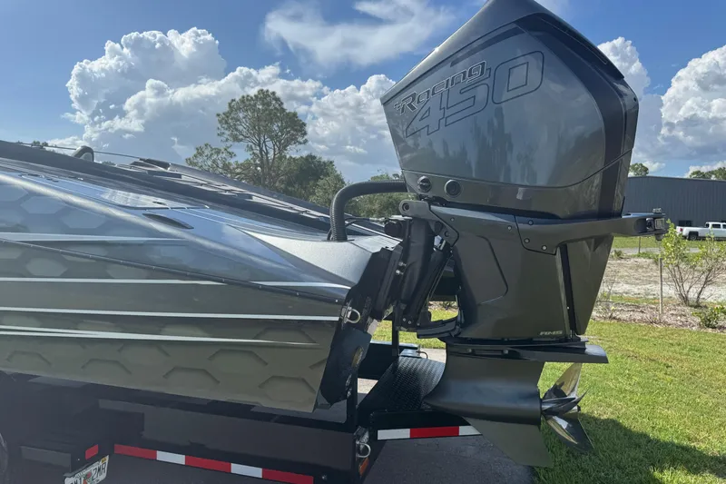Slide: The Image of 2023 MTI 390X boat with Racing 450 engine, parked outdoors under a cloudy sky. - 15