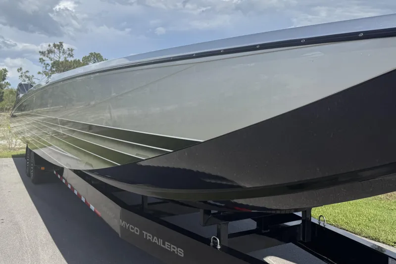 Slide: The Image of 2023 MTI 390X boat on trailer, sleek design under a cloudy sky. - 20