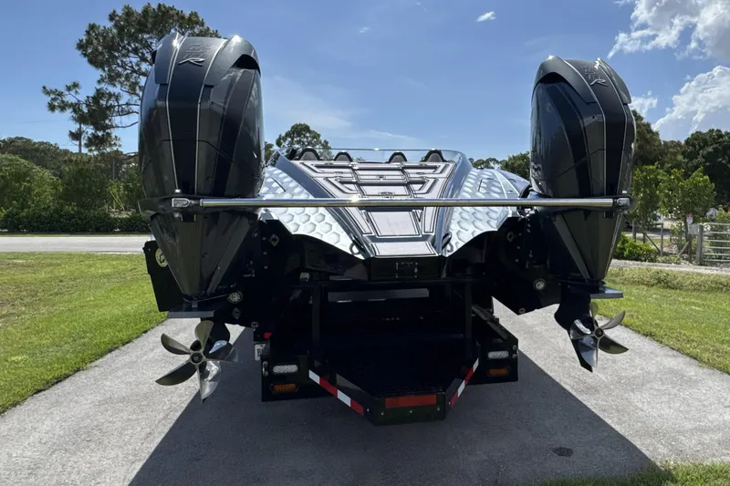 Slide: The Image of 2023 MTI 390X boat with dual outboard engines, parked on a sunny day. - 21