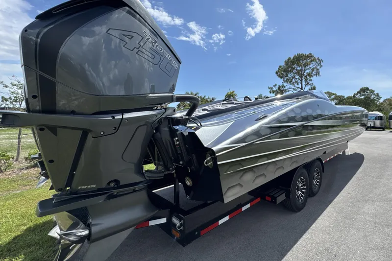 Slide: The Image of 2023 MTI 390X powerboat with 450R engine on trailer, under clear blue sky. - 4