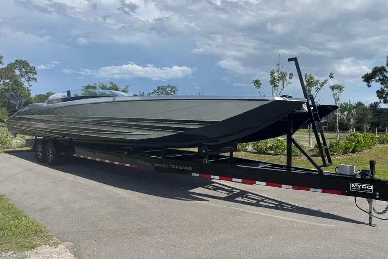 Slide: The Image of 2023 MTI 390X powerboat on trailer under a partly cloudy sky. - 5