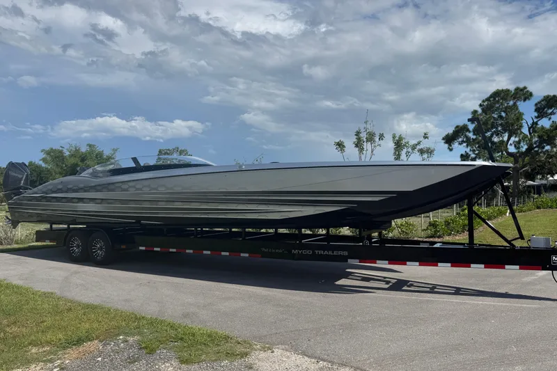Slide: The Image of 2023 MTI 390X powerboat on trailer under a partly cloudy sky. - 7