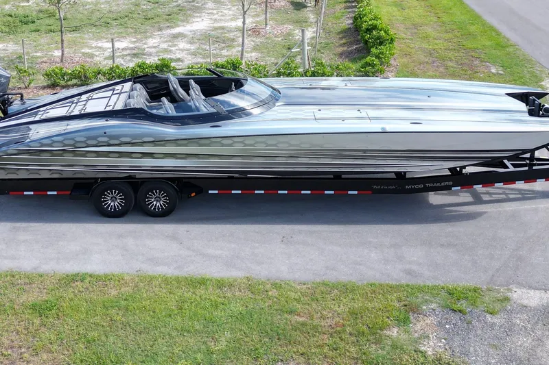 Slide: The Image of 2023 MTI 390X powerboat on trailer, sleek design, parked on roadside. - 8