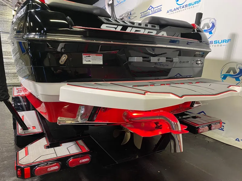 Slide: The Image of Rear view of a 2021 Supra SL 400 boat in a showroom. - 6