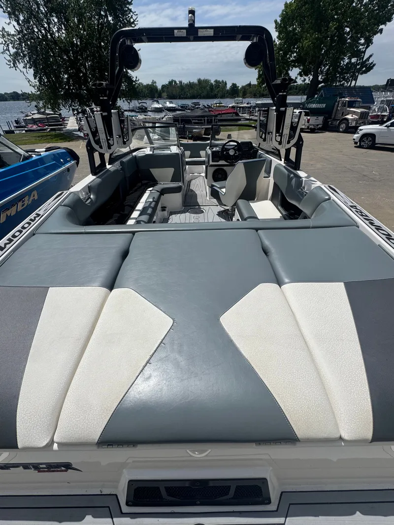 Slide: The Image of 2018 Moomba Max boat with gray and white seating by the lake. - 12