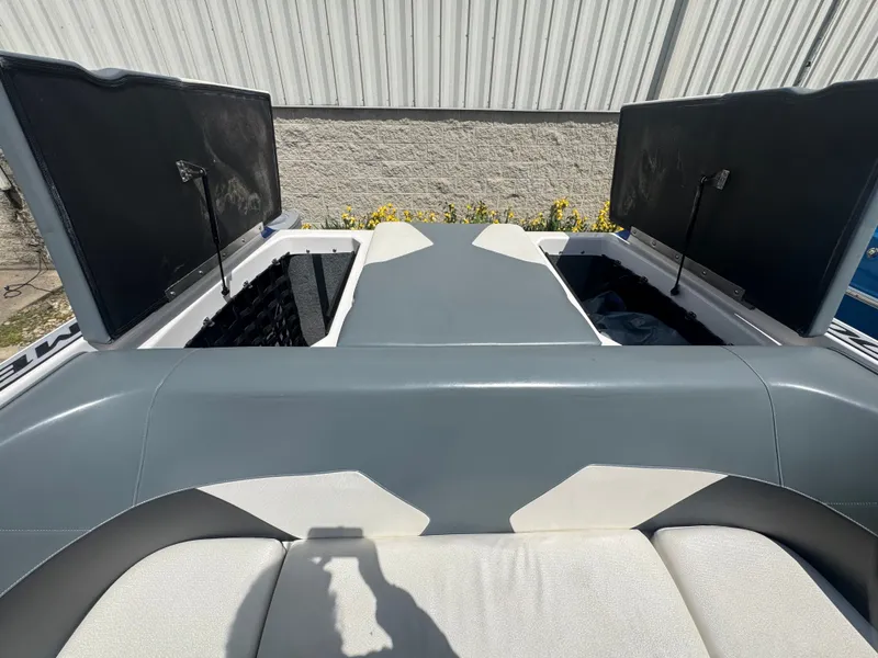 Slide: The Image of 2018 Moomba Max boat with open storage compartments and gray upholstery. - 9