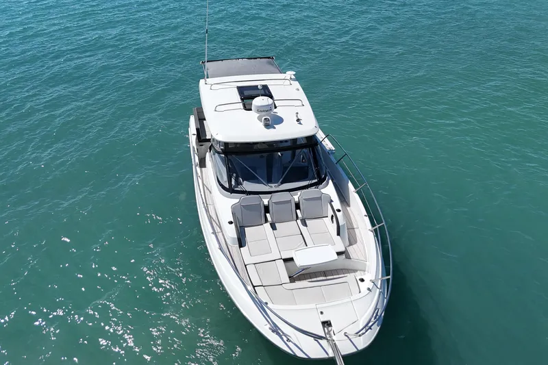 Slide: The Image of 2023 Jeanneau Leader 12.5 WA boat on clear blue water, aerial view. - 2
