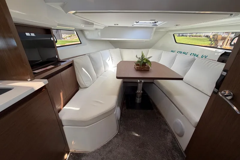 Slide: The Image of Luxurious interior of 2023 Jeanneau Leader 12.5 WA with white seating and wooden table. - 29