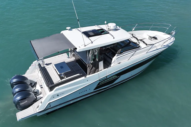 Slide: The Image of 2023 Jeanneau Leader 12.5 WA boat on clear blue water, featuring triple Yamaha engines. - 3