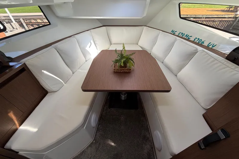 Slide: The Image of Interior of 2023 Jeanneau Leader 12.5 WA with white seating and wooden table. - 30