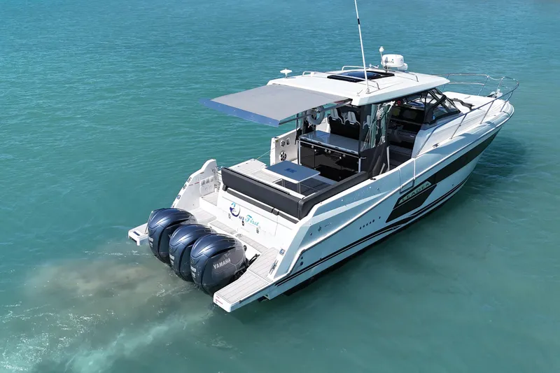 Slide: The Image of 2023 Jeanneau Leader 12.5 WA boat with triple Yamaha engines on clear blue water. - 4
