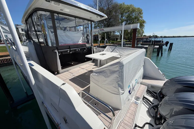 Slide: The Image of 2023 Jeanneau Leader 12.5 WA boat docked, featuring spacious deck and modern design. - 43