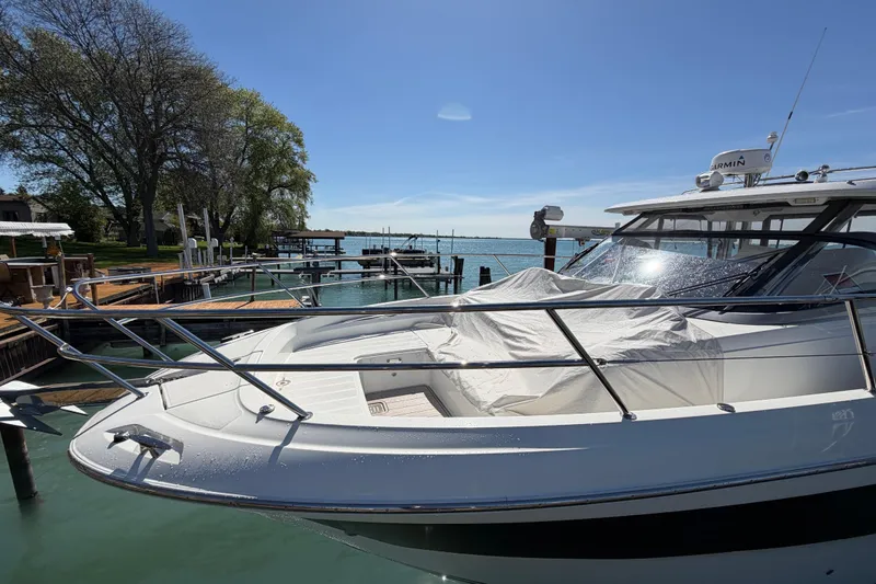 Slide: The Image of 2023 Jeanneau Leader 12.5 WA docked by a serene waterfront under clear blue skies. - 44