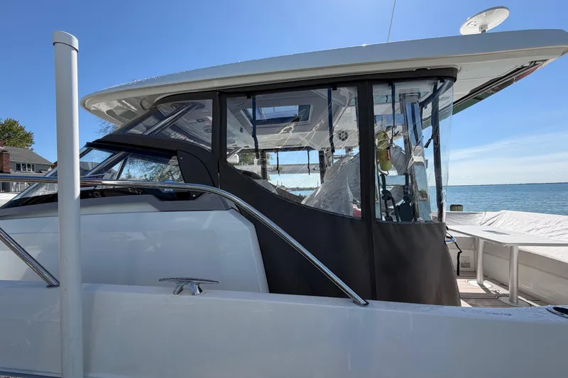 Slide: The Image of 2023 Jeanneau Leader 12.5 WA boat docked, featuring sleek design and enclosed cockpit. - 45