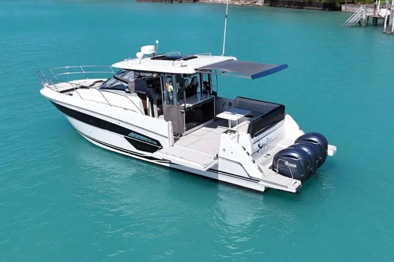 Slide: The Image of 2023 Jeanneau Leader 12.5 WA boat on turquoise water, featuring triple Yamaha engines. - 5
