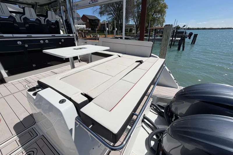 Slide: The Image of 2023 Jeanneau Leader 12.5 WA boat with seating and table, docked by the water. - 9