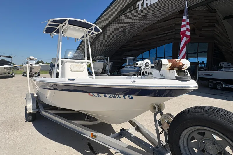 Slide: The Image of 2008 NAUTIC STAR 2110 boat on trailer, parked outside dealership with American flag. - 7