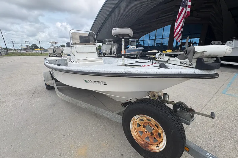 Slide: The Image of 2004 Kenner 18-V boat on trailer, parked outdoors with American flag. - 10