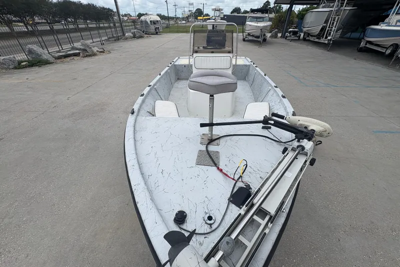 Slide: The Image of 2004 Kenner 18-V boat with trolling motor and seating, parked in a marina. - 11