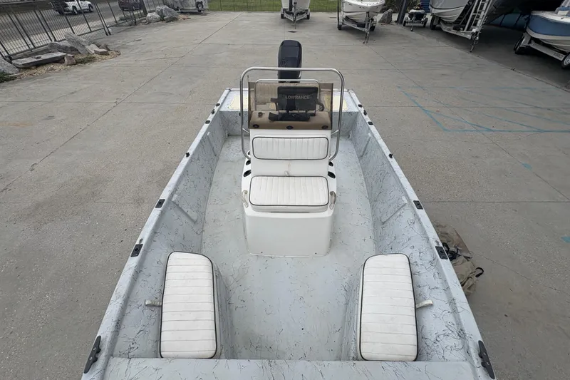 Slide: The Image of 2004 Kenner 18-V boat with white seating, parked in a marina. - 12