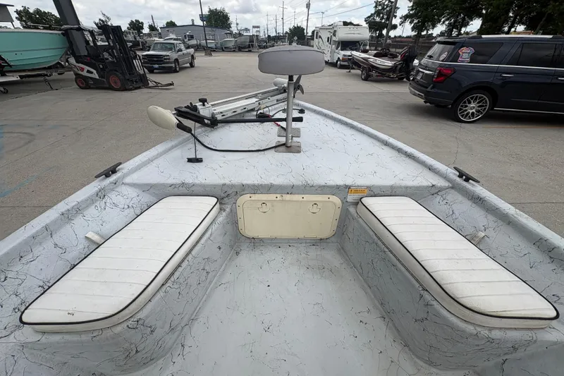 Slide: The Image of 2004 Kenner 18-V boat interior with white seating and trolling motor in a marina setting. - 13