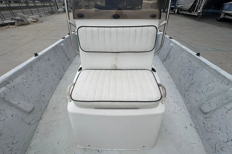 Slide: The Image of 2004 Kenner 18-V boat interior with white cushioned seating and textured flooring. - 14